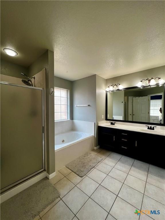 2005 Stonehenge Dr, Harker Heights, TX 76548 - full bathroom featuring a textured ceiling, a bath, a shower stall, tile patterned flooring, and double vanity