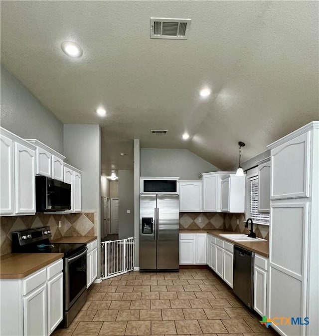 2005 Stonehenge Dr, Harker Heights, TX 76548 - kitchen featuring stainless steel appliances, white cabinets, backsplash, vaulted ceiling, and a textured ceiling