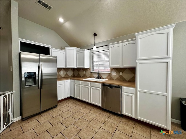 2005 Stonehenge Dr, Harker Heights, TX 76548 - kitchen featuring stainless steel appliances, lofted ceiling, decorative backsplash, white cabinets, and pendant lighting