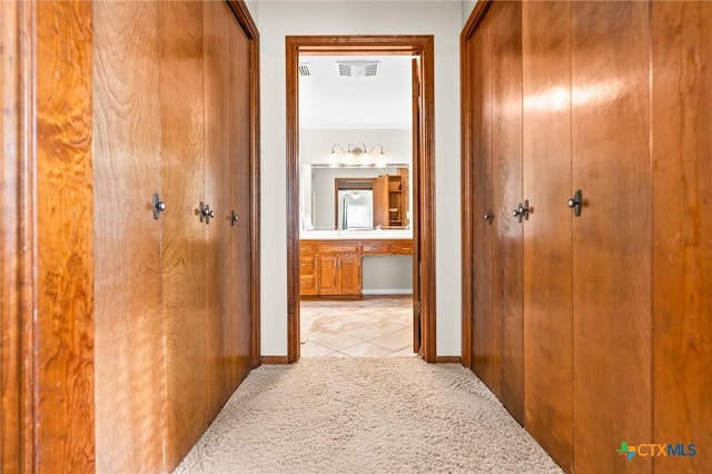 corridor featuring light colored carpet