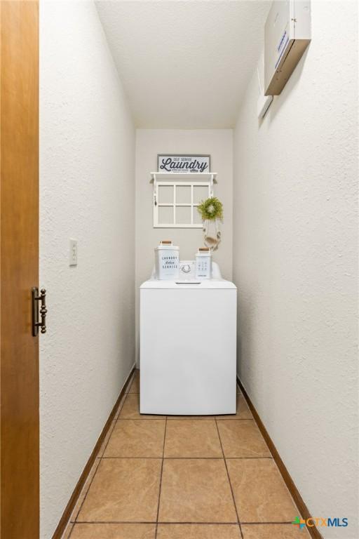 laundry area featuring washer / dryer and light tile patterned floors