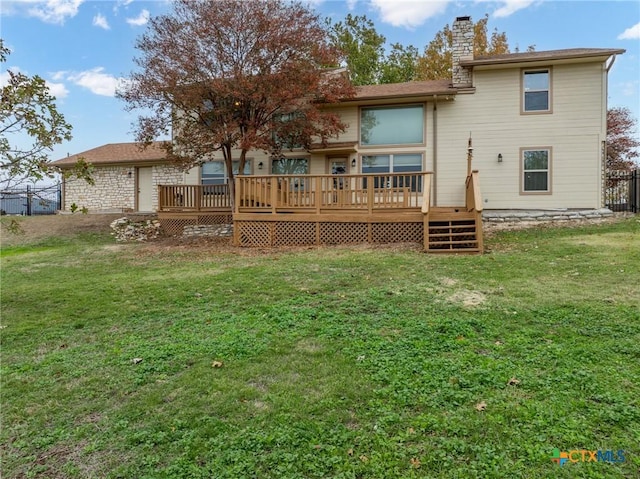 rear view of property featuring a wooden deck and a yard