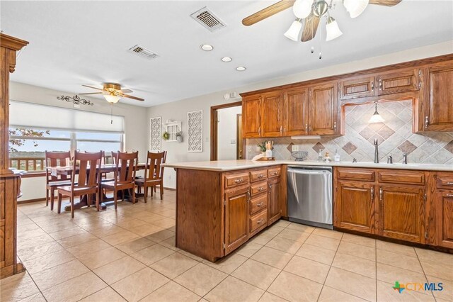 kitchen with backsplash, sink, stainless steel dishwasher, light tile patterned flooring, and kitchen peninsula