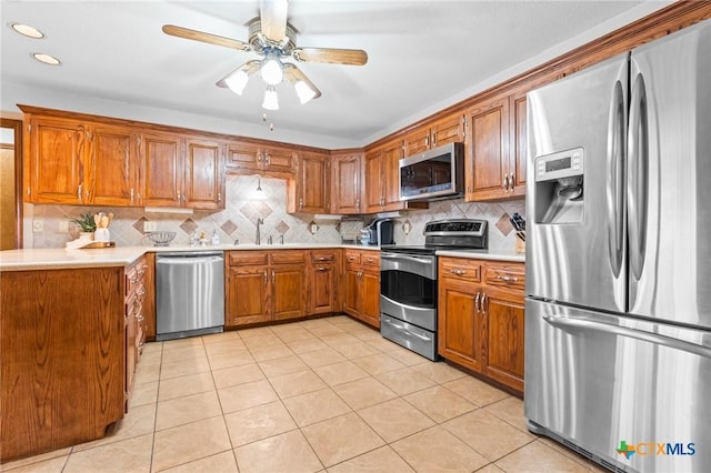 kitchen with decorative backsplash, appliances with stainless steel finishes, and light tile patterned floors