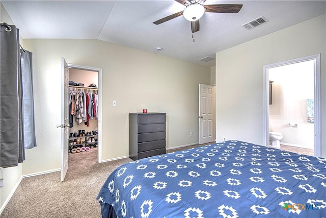 bedroom featuring lofted ceiling, ensuite bath, a spacious closet, carpet floors, and a closet