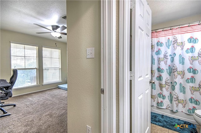 bathroom with shower / bath combination with curtain, ceiling fan, toilet, and a textured ceiling