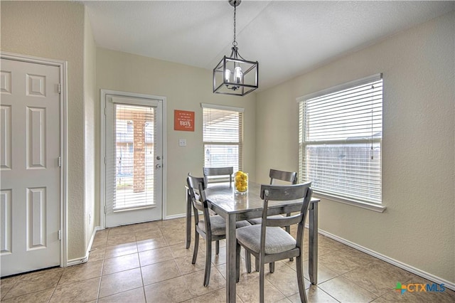 dining area featuring light tile patterned floors and a notable chandelier