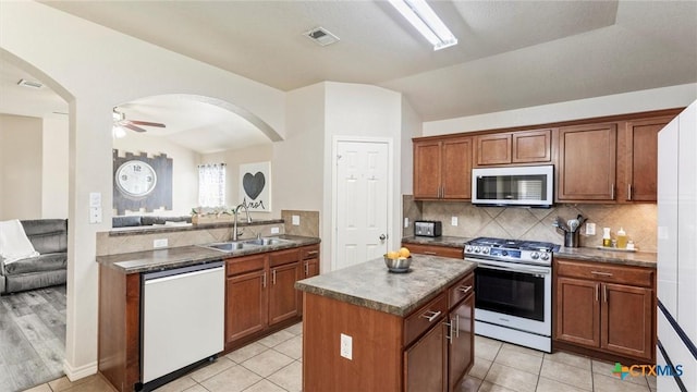 234 Wild Plum, San Marcos, TX 78666 - kitchen with stainless steel range with gas stovetop, white dishwasher, a sink, vaulted ceiling, and a center island