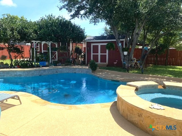 view of pool featuring a shed and an in ground hot tub
