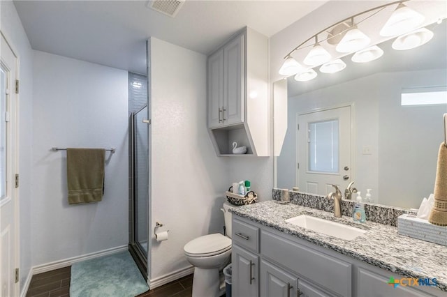 bathroom featuring an enclosed shower, vanity, and toilet