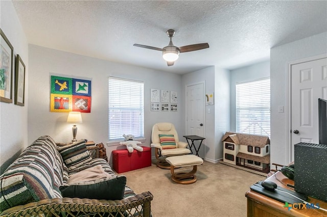 carpeted living room with ceiling fan, a textured ceiling, and a wealth of natural light