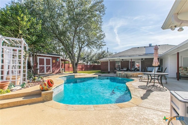 view of pool with a storage unit, ceiling fan, a patio, and pool water feature