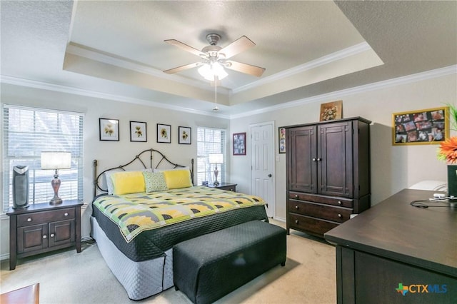 carpeted bedroom with a raised ceiling, ceiling fan, crown molding, and a textured ceiling