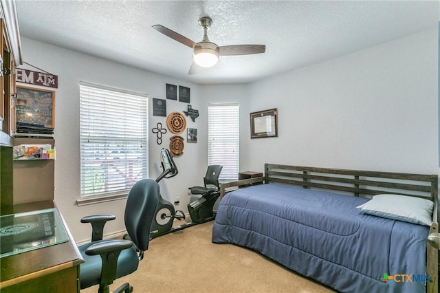 bedroom featuring ceiling fan, carpet floors, and a textured ceiling