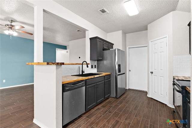 kitchen featuring butcher block countertops, gray cabinets, sink, and stainless steel appliances