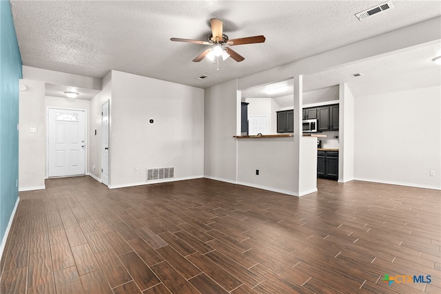 unfurnished living room with a textured ceiling and ceiling fan