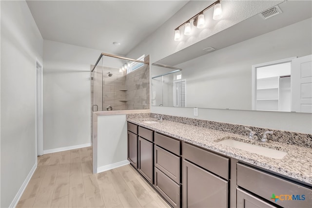 bathroom with hardwood / wood-style flooring, vanity, and an enclosed shower