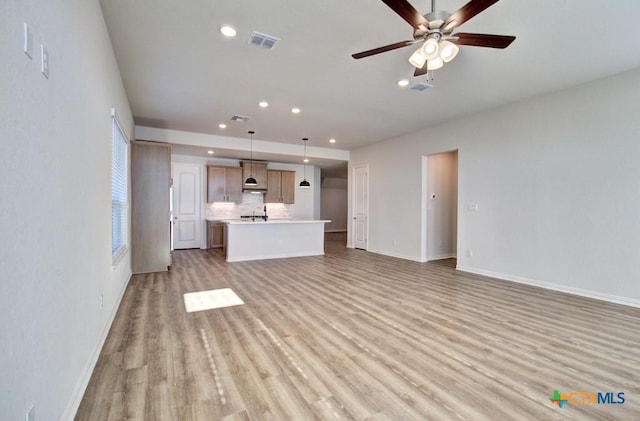 unfurnished living room featuring light hardwood / wood-style floors and ceiling fan