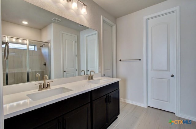 bathroom featuring vanity and an enclosed shower