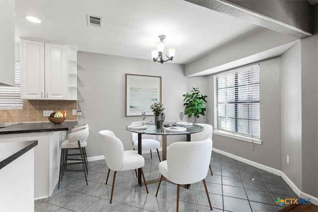 12103 Wycliff Ln, Austin, TX 78727 - tiled dining room featuring a chandelier and baseboards