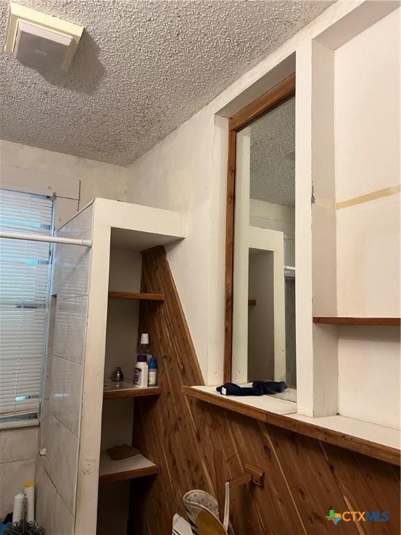 310 Smith Ln Unit A, San Marcos, TX 78666 - bathroom featuring a textured ceiling and a shower