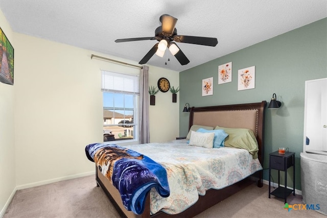 carpeted bedroom with a ceiling fan, a textured ceiling, and baseboards