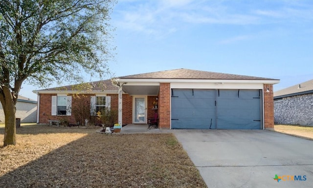 single story home with a garage, brick siding, and driveway