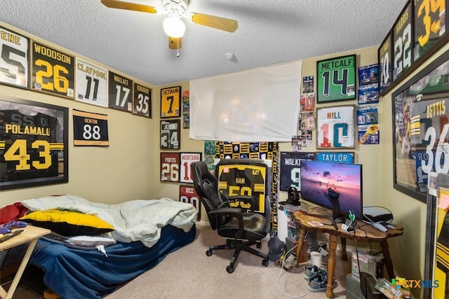 carpeted home office featuring a textured ceiling and ceiling fan