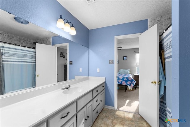 ensuite bathroom featuring a textured ceiling, ensuite bath, and vanity