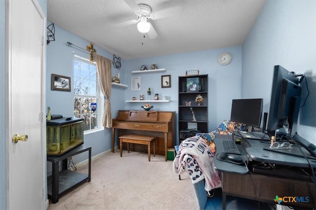 carpeted office space with baseboards, a ceiling fan, and a textured ceiling