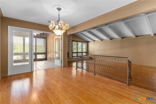 interior space with hardwood / wood-style flooring, ceiling fan with notable chandelier, ornamental molding, and vaulted ceiling with beams