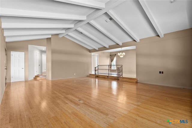 unfurnished living room with light hardwood / wood-style flooring, lofted ceiling with beams, and a notable chandelier