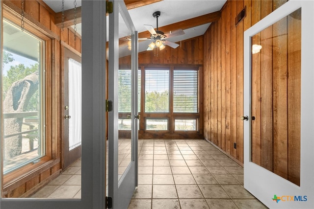 unfurnished sunroom featuring ceiling fan and vaulted ceiling with beams