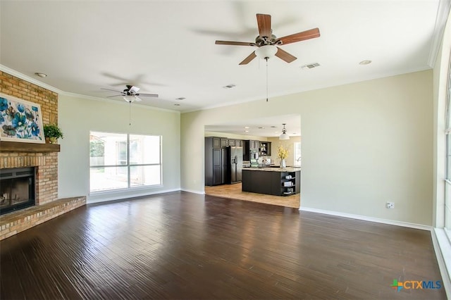 4113 Fm 1670, Belton, TX 76513 - unfurnished living room featuring ceiling fan, wood finished floors, a brick fireplace, and crown molding