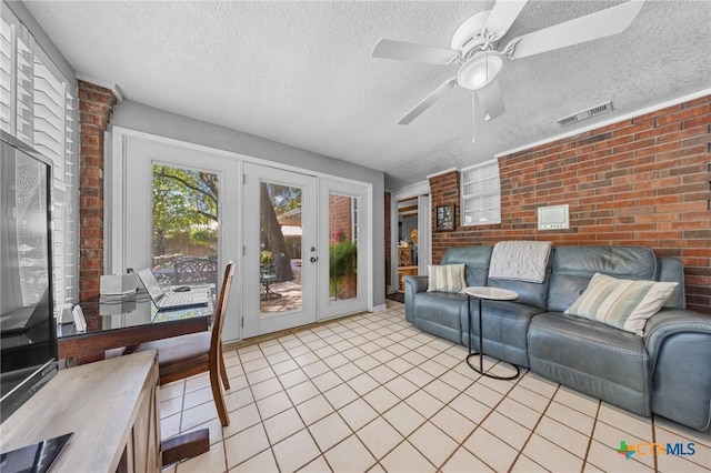 2203 Antelope Trl, Harker Heights, TX 76548 - living room with brick wall, a textured ceiling, french doors, light tile patterned floors, and a ceiling fan