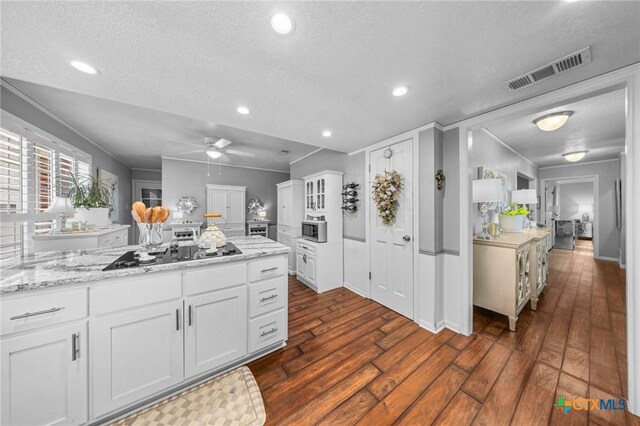 2203 Antelope Trl, Harker Heights, TX 76548 - kitchen with dark wood-style flooring, cooktop, ceiling fan, a textured ceiling, and white cabinetry