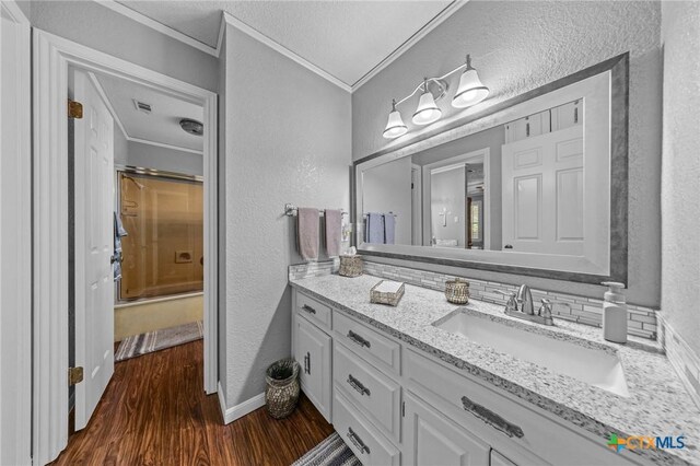 2203 Antelope Trl, Harker Heights, TX 76548 - bathroom featuring ornamental molding, vanity, a textured wall, wood finished floors, and a shower