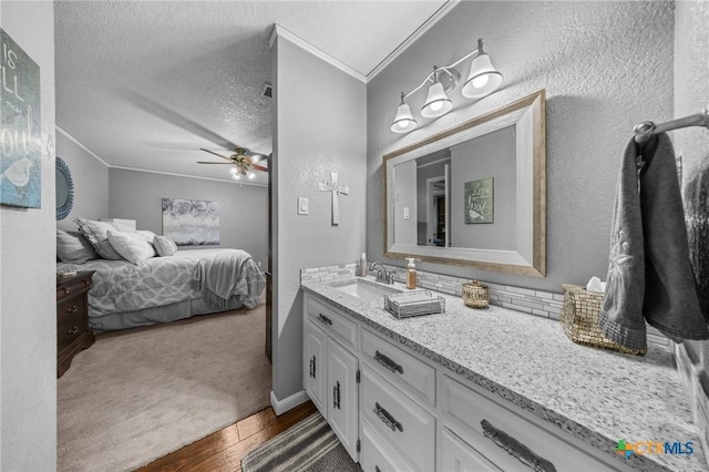 2203 Antelope Trl, Harker Heights, TX 76548 - ensuite bathroom with ornamental molding, vanity, a textured wall, a ceiling fan, and wood finished floors
