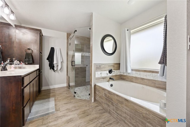 2416 Macdougal St, Nolanville, TX 76559 - bathroom featuring a shower stall, a bath, vanity, wood finished floors, and baseboards