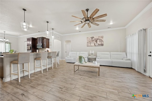 2416 Macdougal St, Nolanville, TX 76559 - living room with ornamental molding, arched walkways, ceiling fan, light wood-type flooring, and a chandelier