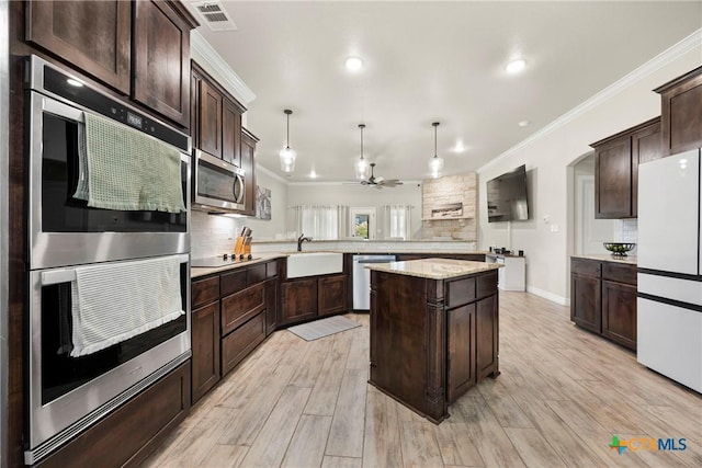 2416 Macdougal St, Nolanville, TX 76559 - kitchen with stainless steel appliances, a peninsula, dark brown cabinets, a sink, and tasteful backsplash