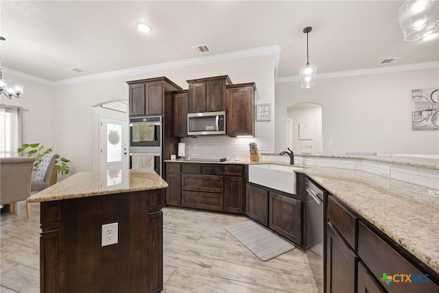 2416 Macdougal St, Nolanville, TX 76559 - kitchen with arched walkways, stainless steel appliances, dark brown cabinetry, light stone counters, and tasteful backsplash
