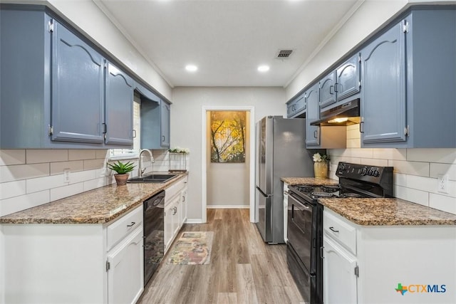 15 Willow Ct, Belton, TX 76513 - kitchen with black appliances, a sink, blue cabinets, light wood-style flooring, and decorative backsplash