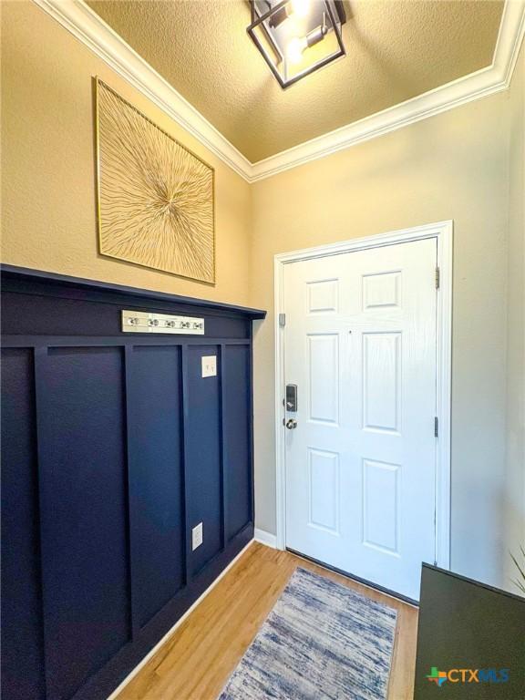 2321 Vicksburg Ln, Temple, TX 76504 - foyer entrance featuring light wood-style flooring, ornamental molding, and a textured ceiling