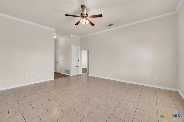 spare room with crown molding, arched walkways, visible vents, and ceiling fan