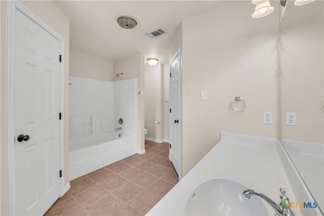 full bath with visible vents, a sink, shower / washtub combination, tile patterned floors, and toilet