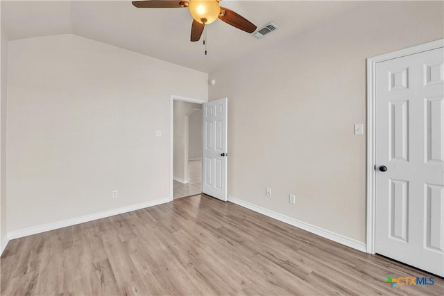 unfurnished bedroom featuring lofted ceiling, light wood-style floors, visible vents, and baseboards