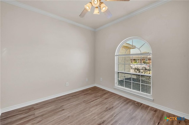 empty room featuring wood finished floors, crown molding, a ceiling fan, and baseboards