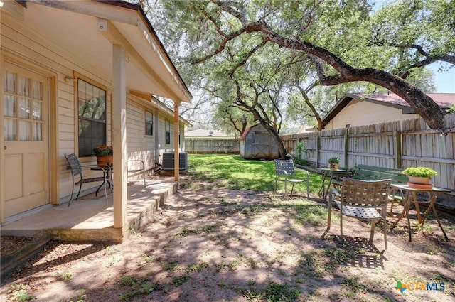 view of yard featuring a storage shed, central AC, and a patio