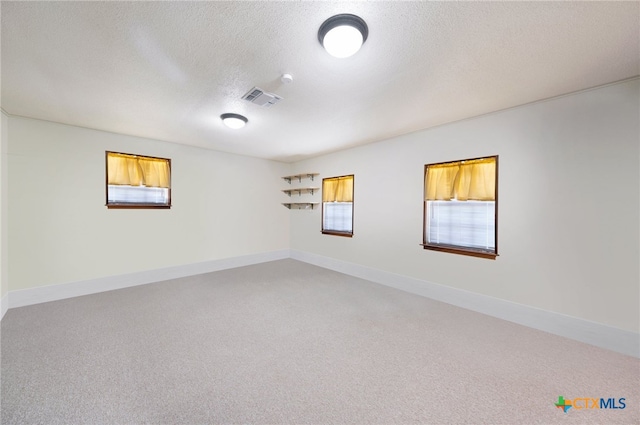 carpeted spare room with a textured ceiling